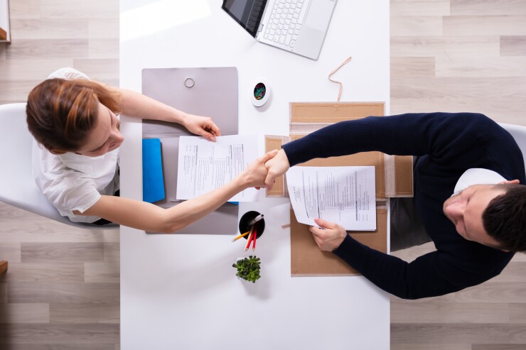 Businessman Shaking Hand With Female Applicant