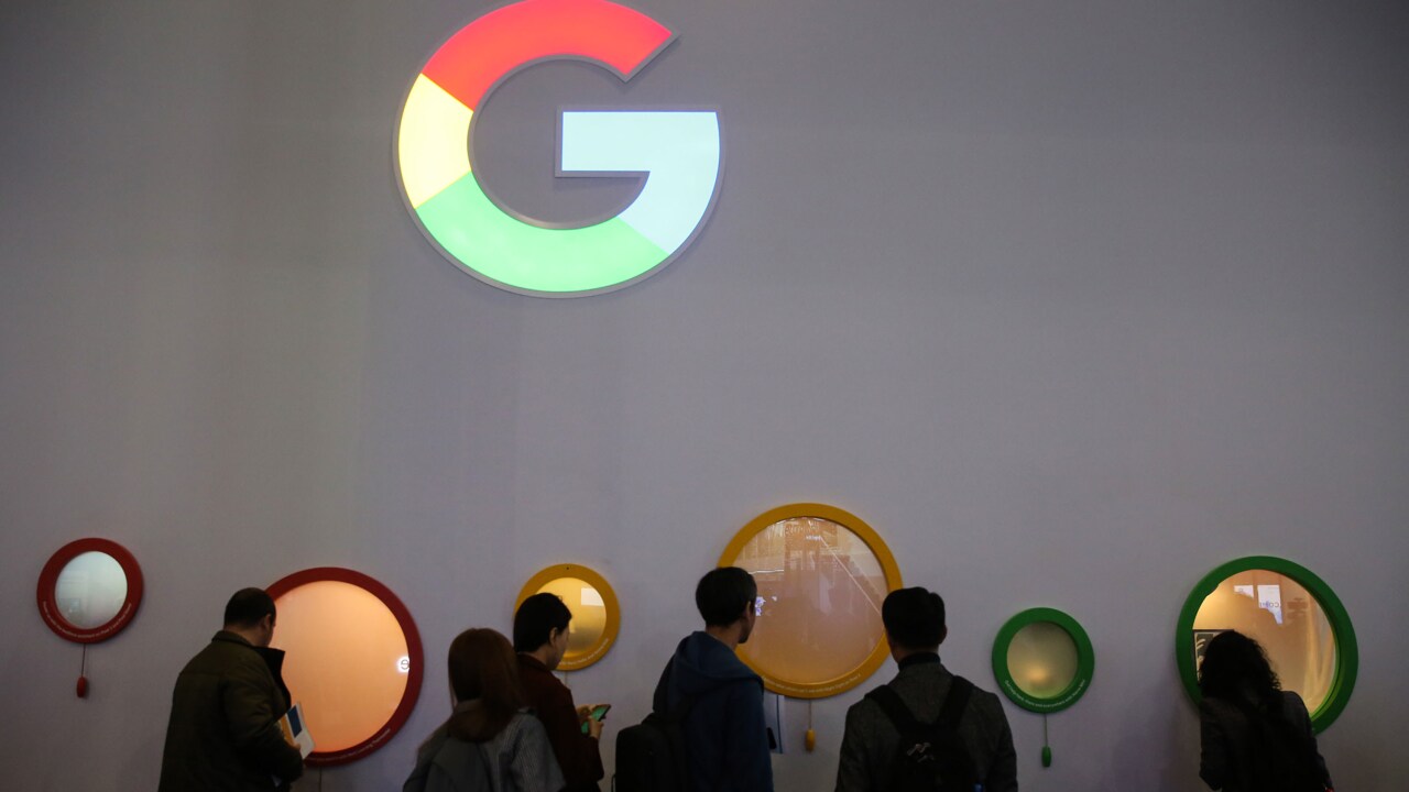 Attendees peer through portholes on the Google Inc. stand on the opening day of the MWC Barcelona in Barcelona, Spain.