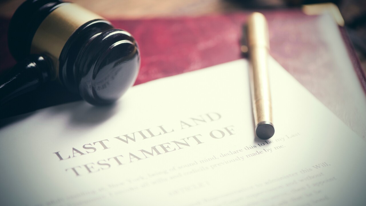 A gavel and pen sit on top of a document marked 'last will and testament'