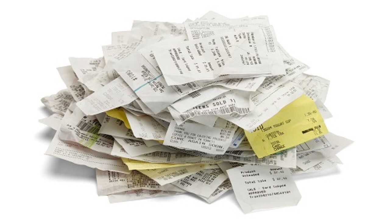 Heap of paper sales receipts in a mound isolated on white background.