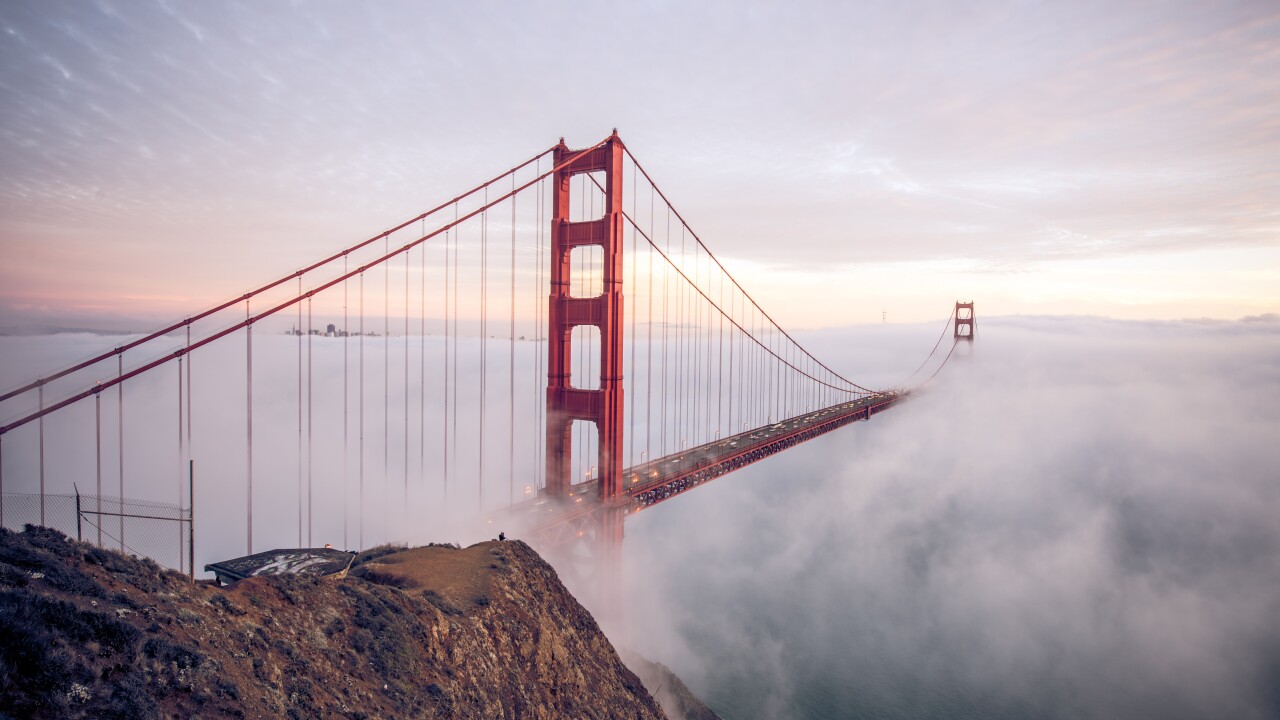 The Golden Gate Bridge in San Francisco looms above the fog in the early morning hours.