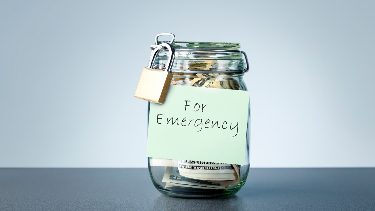 A locked glass jar with money in it that's labeled "for emergency"