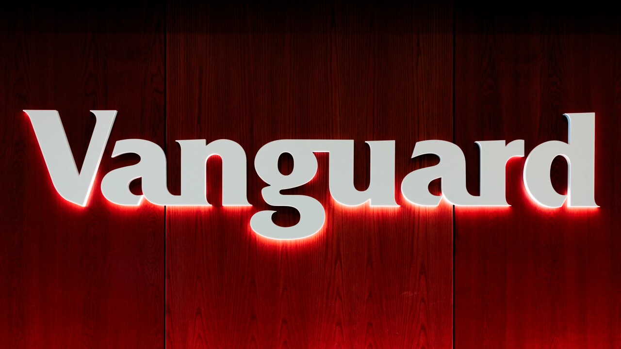 The investment management company name "Vanguard" is spelled out in white letters against a red backdrop on a wall in the firm's offices.