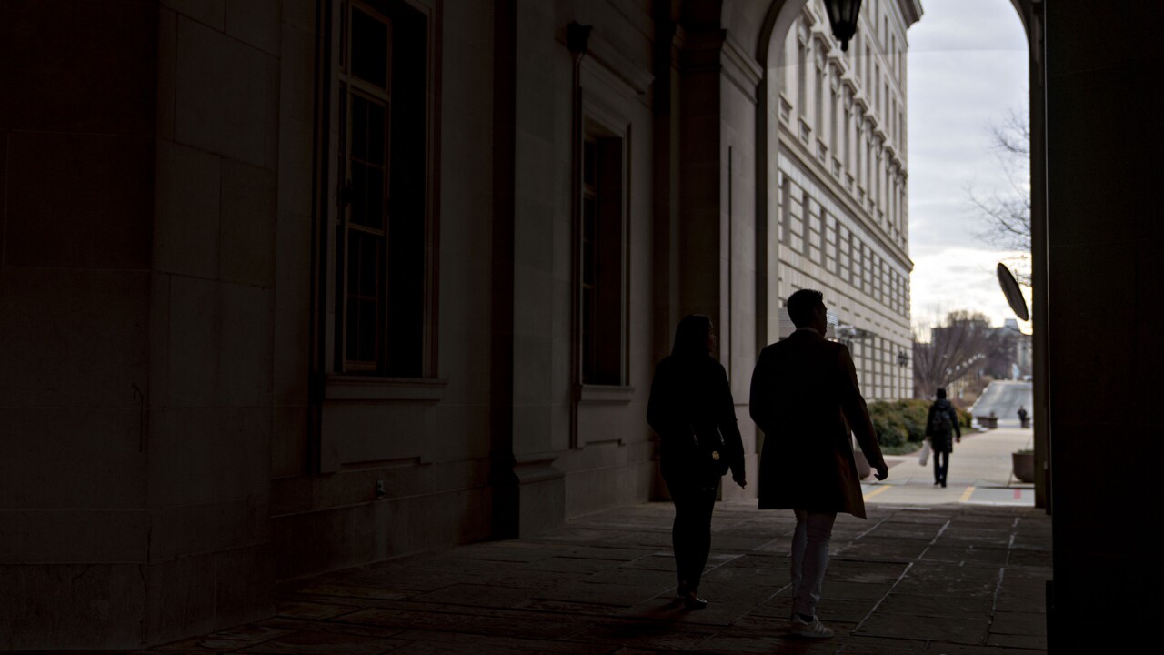 Pedestrians walk through the IRS headquarters in Washington, D.C.