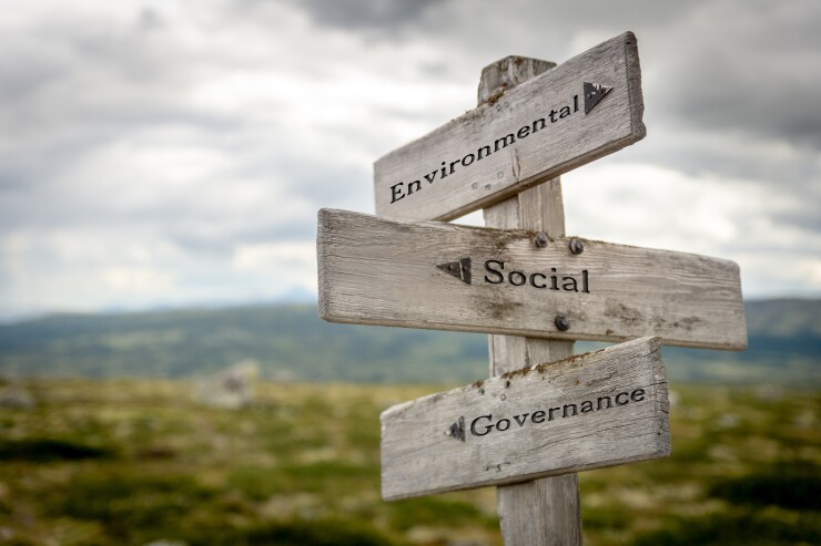 Environmental social governance (ESG) text on wooden signpost outdoors in nature