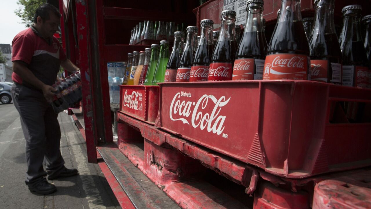 A delivery employee of Coca cola company unloads a package of Coca cola bottles from the delivery truck in the Zona Rosa area in Mexico city, Mexico, on Wednesday, April 2st, 2014. Photo:Susana González/Bloomberg